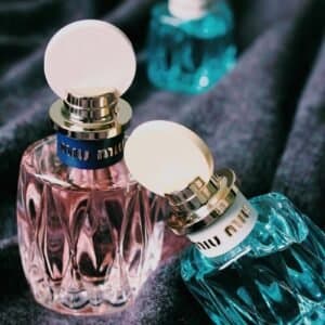 three green and pink bottles on black textile